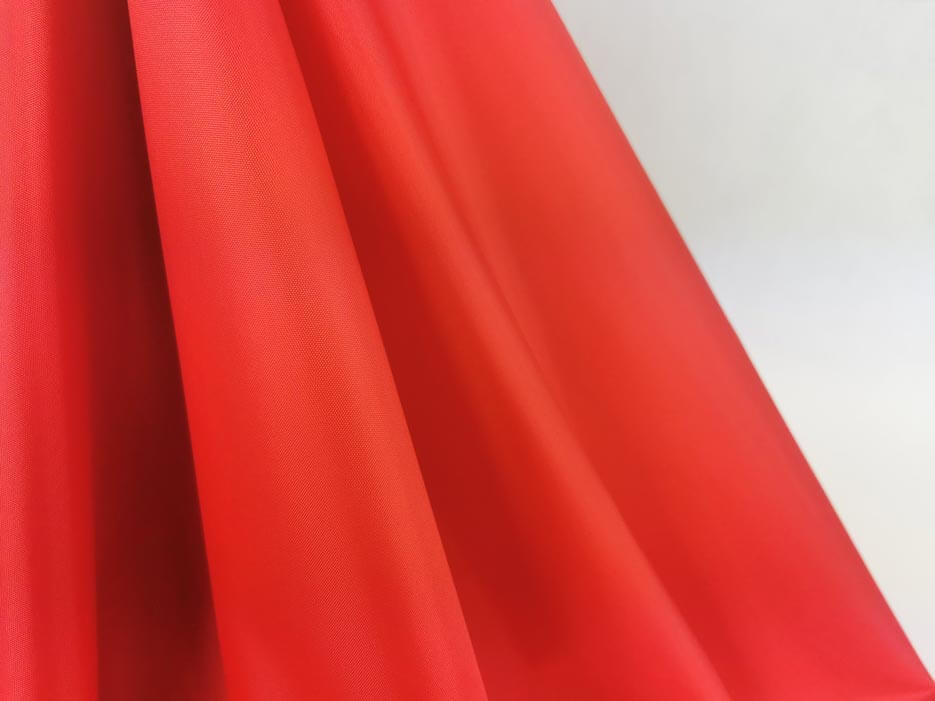 Zdjęcie przedstawiające czerwoną tkaninę wodoodporną  Ortalion w przybliżeniu na strukturę materiału