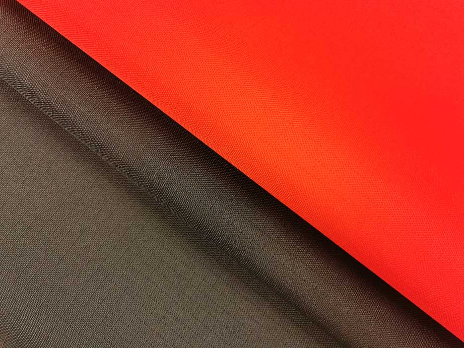 Zdjęcie przedstawiajace tkaninę wodoodporną Ripstop w dwóch kolorach- czarnym i czerwonym w przybliżeniu