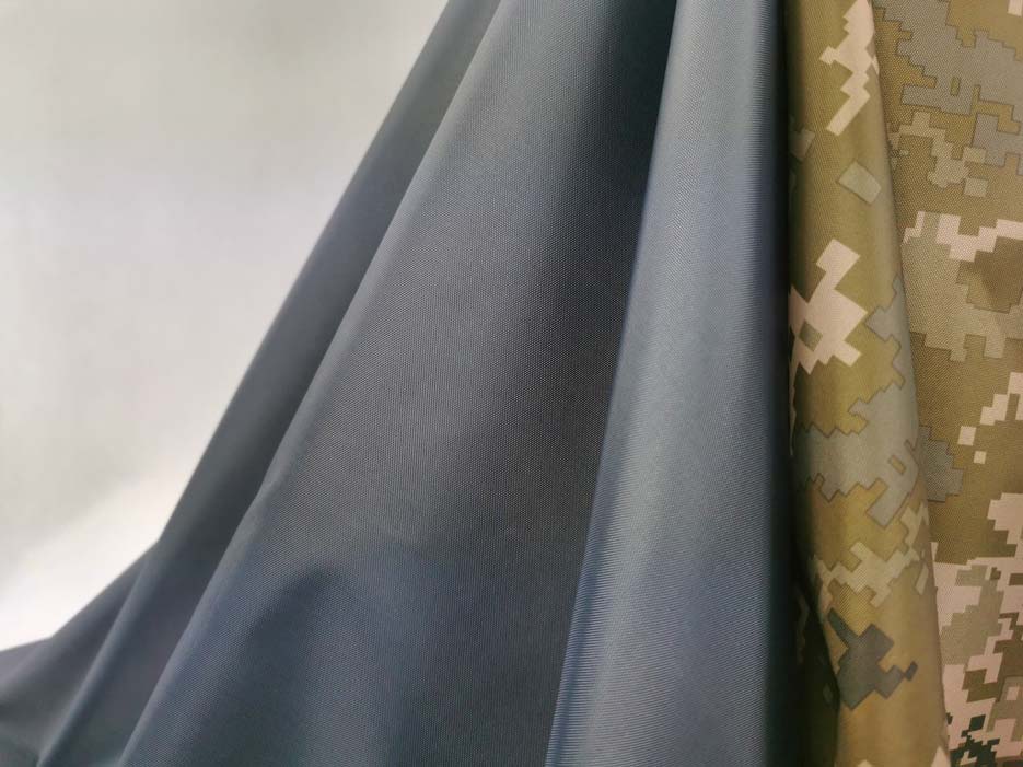 Zdjęcie przedstawiające tkaninę wodoodporną ortalion w kolorze szarym oraz z motywem moro 