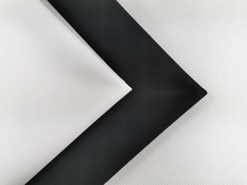 Zdjęcie prezentujące materiał wodoodporny, tkaninę Oxford S44 na pokrowce i poduszki ogrodowe w kolorze białym i czarnym