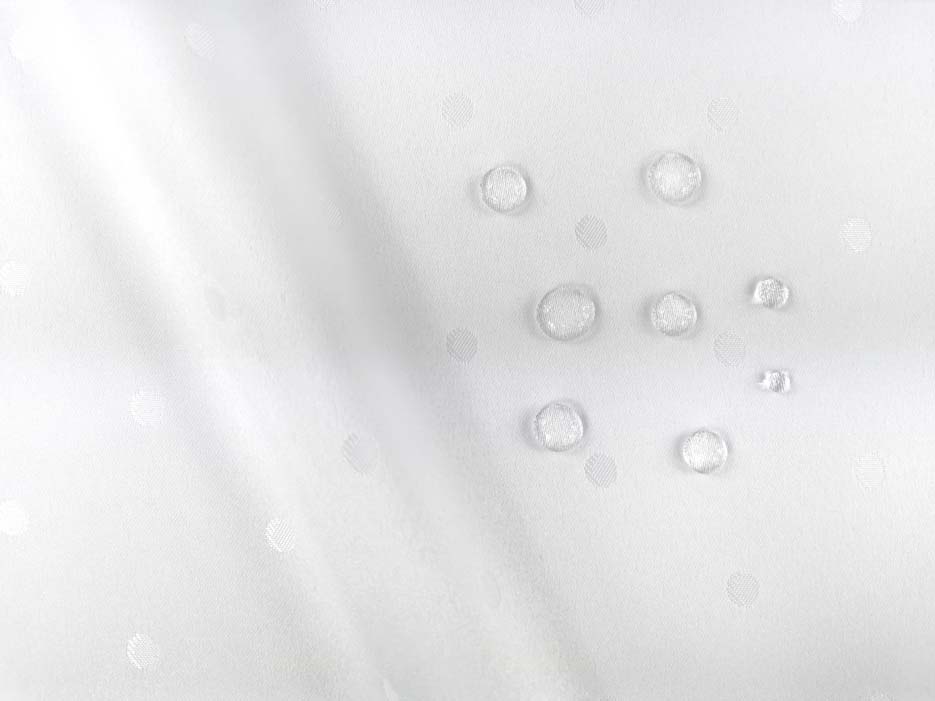 Zdjęcie przedstawiające tkaninę żakardowa obrusową, plamoodporną w kolorze białym z kroplami wody na powierzchni materiału