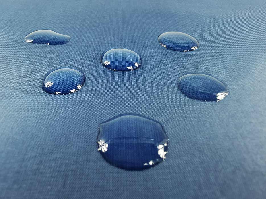 Zdjęcie przedstawiające wodoodporną tkaninę Ortalion z kroplami wody na powierzchni materiału 