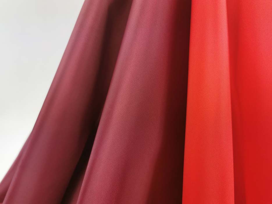 Zdjęcie prezentujące tkaninę ortalion wodoodporny w odcieniach czerwieni w przybliżeniu