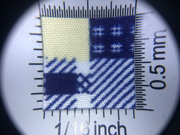 Zdjęcie przedstawia art. BS616, (100% poliester, gramatura 70 g/m2, szerokość 165 cm) w kolorze niebieskim (nr. 5136), we wzorze 702, w przybliżeniu, pod lupą, wygląd struktury tkaniny.