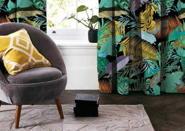 Zdjęcie przedstawiające wizualizację wzoru do druku na tkaninach dekoracyjnych, zasłonowych w egzotyczne liście palmowe w kolorze żółtym, pomarańczowym, zielonym i niebieskim na tle w kolorze czarnym