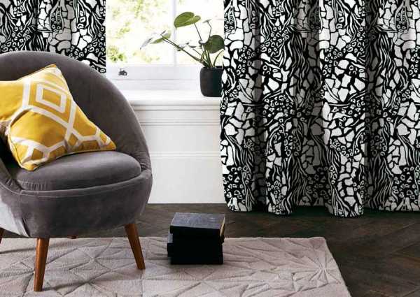Zdjęcie przedstawiające wizualizację wzoru do druku na tkaninach dekoracyjnych, zasłonowych w nieregularne białe cętki i pasy zebry kształty na czarnym tle