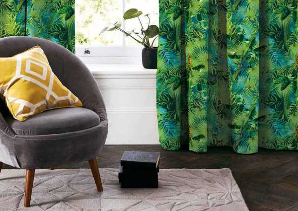 Zdjęcie przedstawiające wizualizację wzoru do druku na tkaninach dekoracyjnych, zasłonowych w tropikalne liście palmowe w odcieniach zieleni na tle w kolorze jasnego błękitu