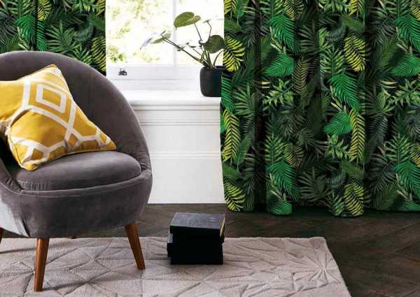 Zdjęcie przedstawiające wizualizację wzoru do druku na tkaninach dekoracyjnych, zasłonowych w egzotyczne liście palmowe w odcieniach zieleni na tle w kolorze czarnym