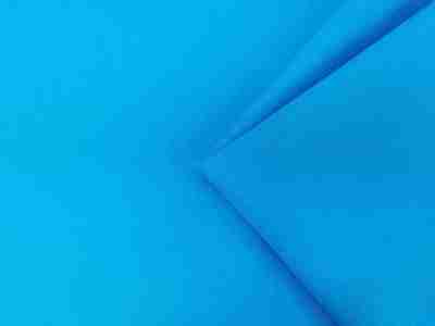 Zdjęcie prezentujące przybliżenie na tkaninę poliestrową w kolorze niebieskim, odcieniu ciemnego błękitu 