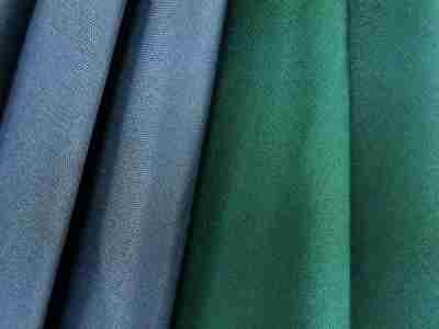 Zdjęcie prezentujące tkaninę elanobawełnę w kolorze szarym i zielonym w przybliżeniu na strukturę materiału