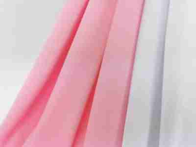 Zdjęcie prezentujące różową oraz białą elanobawełnę na odzież medyczną, tkaninę Radus 1203