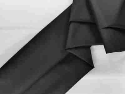 Zdjęcie prezentujące czarną tkaninę wodoodporną Oxford S44 na tle materiału w kolorze białym