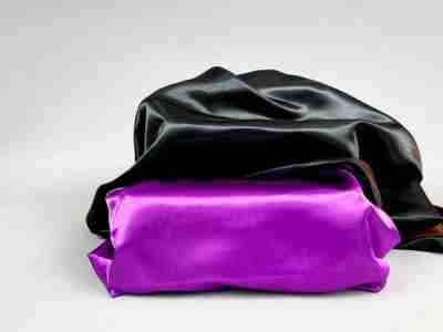 Zdjęcie przedstawiające fioletową i czarną tkaninę satynową (atłas), 100% poliester