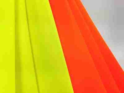 Zdjęcie prezentujące seledynową oraz jaskrawo pomarańczową tkaninę Elanobawełnę Biver, materiał na odzież roboczą