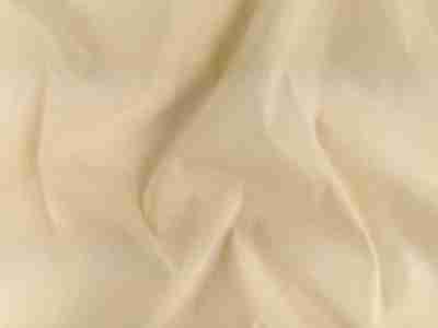 Zdjęcie przedstawiające naturalną, surową tkaninę bawełnianą w przybliżeniu na strukturę materiału