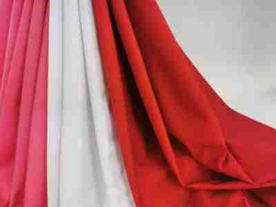 Zdjęcie prezentujące tkaninę Radus 1202, elanobawełnę na fartuszki medyczne, w kolorze różowym, białym oraz czerwonym w swobodnym ułożeniu