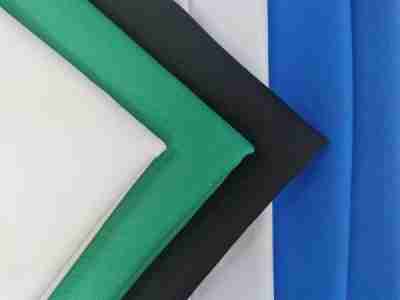 Zdjęcie prezentujące tkaninę poliestrową Diagonal 1023 w palecie przykładowych kolorów, białym, zielonym, czarnym, kremowym oraz niebieskim