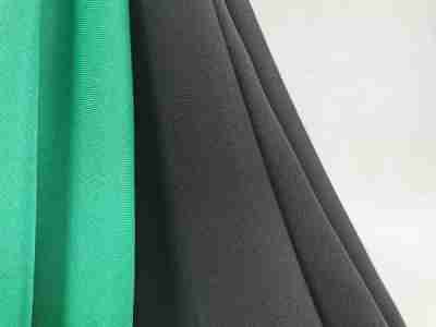 Zdjęcie przedstawiające zieloną oraz czarną tkaninę poliestrową Diagonal- materiał na odzież wierzchnią
