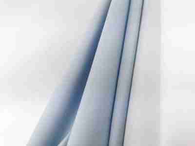 Zdjęcie prezentujące niebieski oraz biały materiał poliestrowy z dodatkiem wiskozy w swobodnym ułożeniu 