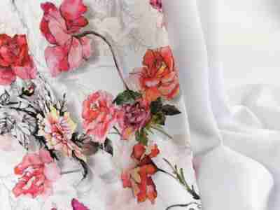 Zdjęcie przedstawia materiał na sukienkę Żorżeta w kolorze białym oraz z nadrukiem w kolorowe kwiaty