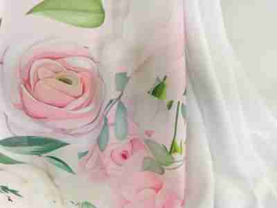 Zdjęcie przedstawia poliestrową tkaninę Żorżeta-materiał na sukienki i alby- z nadrukiem w róże i kolorze białym