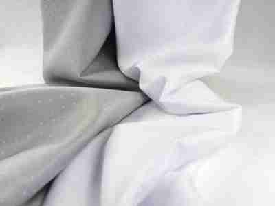 Zdjęcie przedstawiajace tkaninę żakardowa obrusową z motywem łezki w kolorze szarym i białym