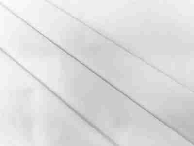 Zdjęcie prezentujące białą tkaninę bawełnianą o splocie skośnym, materiał Drelich, w przybliżeniu