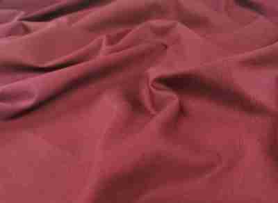Zdjęcie prezentujące przybliżenie na bordową tkaninę bawełnianą drelichową w swobodnym ułożeniu