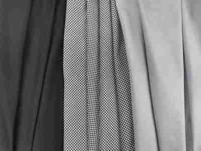 Zdjęcie przedstawiające Elanobawełnę, tkaninę na uniformy medyczne, w kolorze czarnym, ze wzorem w popitkę oraz jasnej szarości
