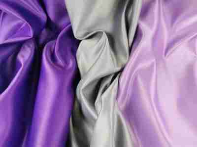 Zdjęcie przedstawiające tkaninę obrusową plamoodporną AXB w trzech kolorach-ciemnofioletowym, szarym i lawendowym