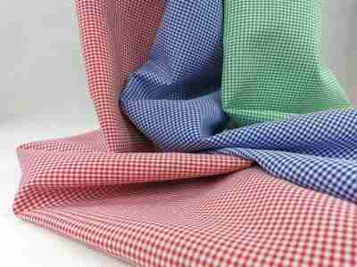 Zdjęcie prezentujące tkaninę panama we wzorze drobnej kratki vichy w kolorach biało-czerwonym, biało-niebieskim oraz biało-zielonym