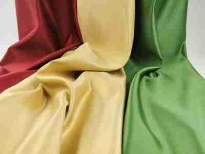 Zdjęcie prezentujące tkaninę obrusową w trzech kolorach- czerwonym, złotym i zielonym