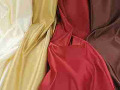 Zdjęcie prezentujące tkaninę obrusową, atłasową w kolorach- kremowym, złotym, czerwonym oraz brązowym