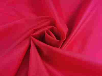 Zdjęcie prezentujące czerwona tkaninę wodoodporną, ortalion w przybliżeniu na strukturę materiału